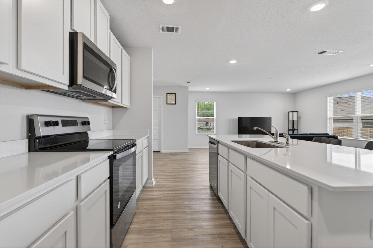 2637 Saltgrass Way Crestview, FL 32536 - Photo 15 of 47 a kitchen with stainless steel appliances a sink dishwasher stove refrigerator and microwave