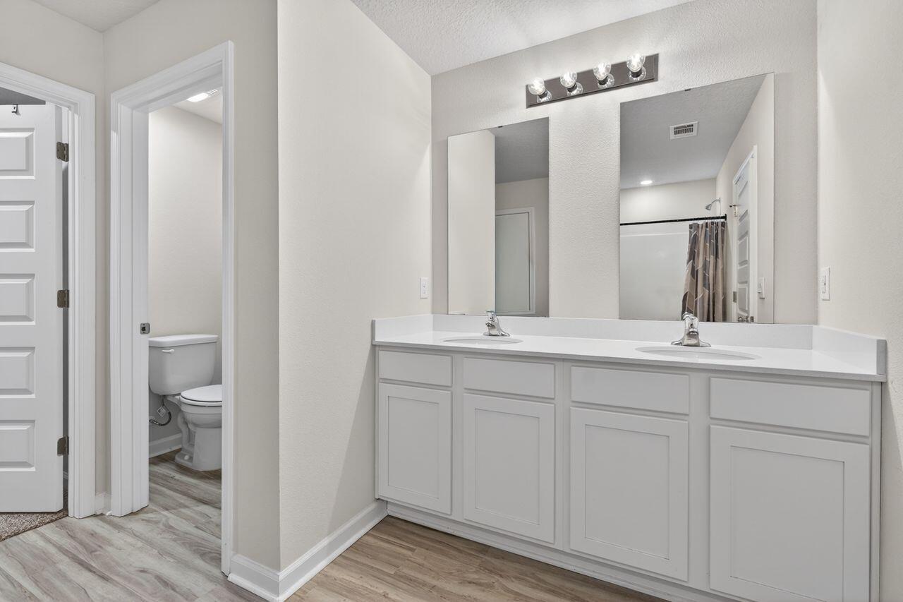2637 Saltgrass Way Crestview, FL 32536 - Photo 32 of 47 a bathroom with a double vanity sink and a mirror