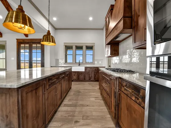 a large kitchen with stainless steel appliances granite countertop lots of counter space and a wooden cabinets