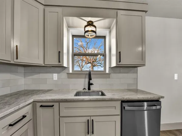 a kitchen with stainless steel appliances granite countertop a sink and a white cabinets