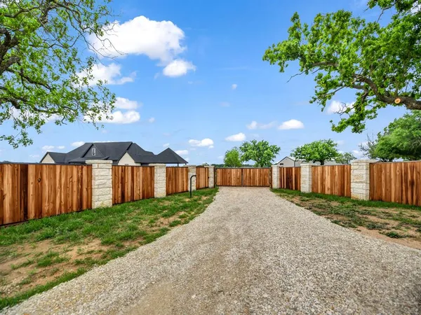a view of backyard with potted plants and wooden fence