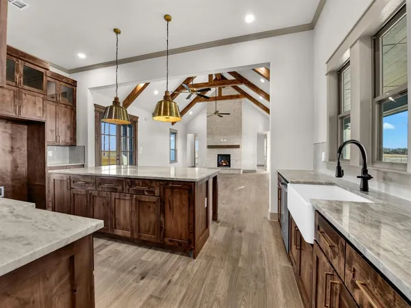 a kitchen with stainless steel appliances granite countertop a sink a stove and a wooden floors