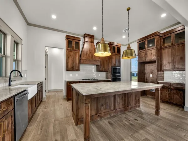 a large kitchen with stainless steel appliances a stove center island a refrigerator and a view of living room