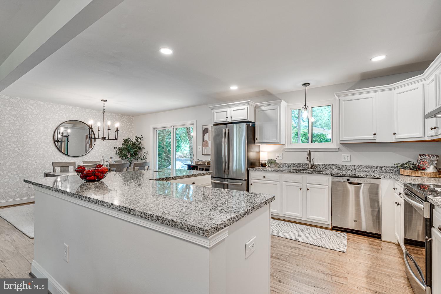 10197 Wavell Road Fairfax, VA 22032 - Photo 15 of 47 a kitchen with stainless steel appliances granite countertop a sink dishwasher a stove a refrigerator and a dining table with wooden floor