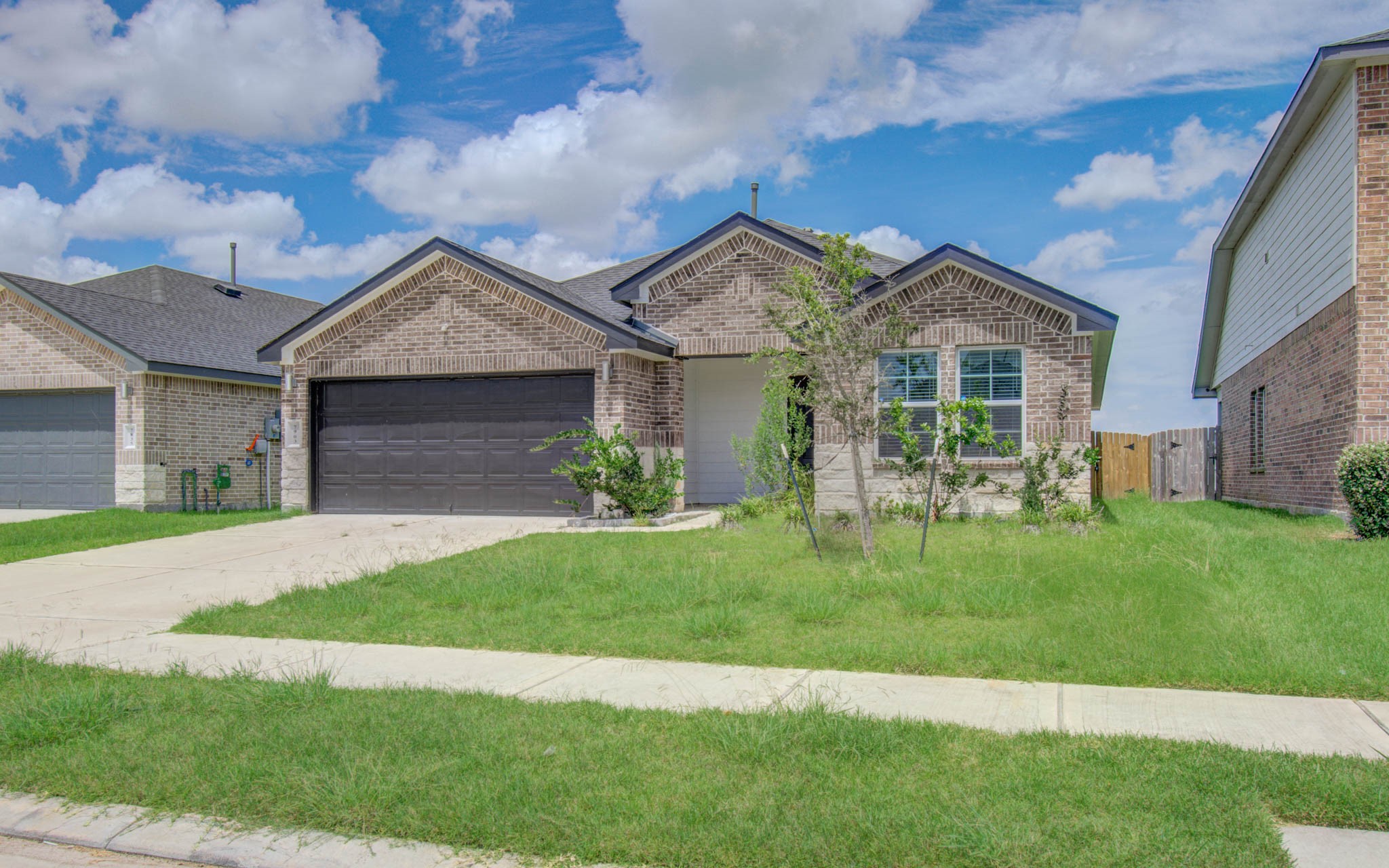 7903 Wrangler Shack Lane Rosharon, TX 77583 - Photo 2 of 29 Discover comfortable living in this charming single-story brick home featuring a cozy front porch, lush green lawn, and a two-car garage, nestled in a welcoming neighborhood.