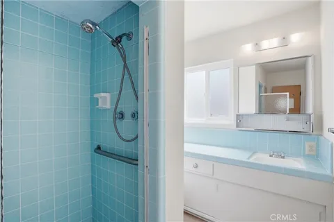 a bathroom with a granite countertop sink a toilet and shower