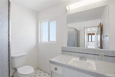 a bathroom with a sink toilet and mirror