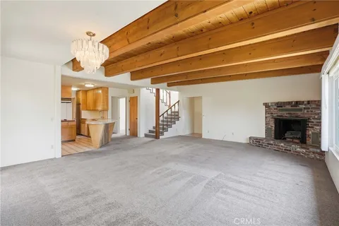 a view of an empty room with a fireplace and a window