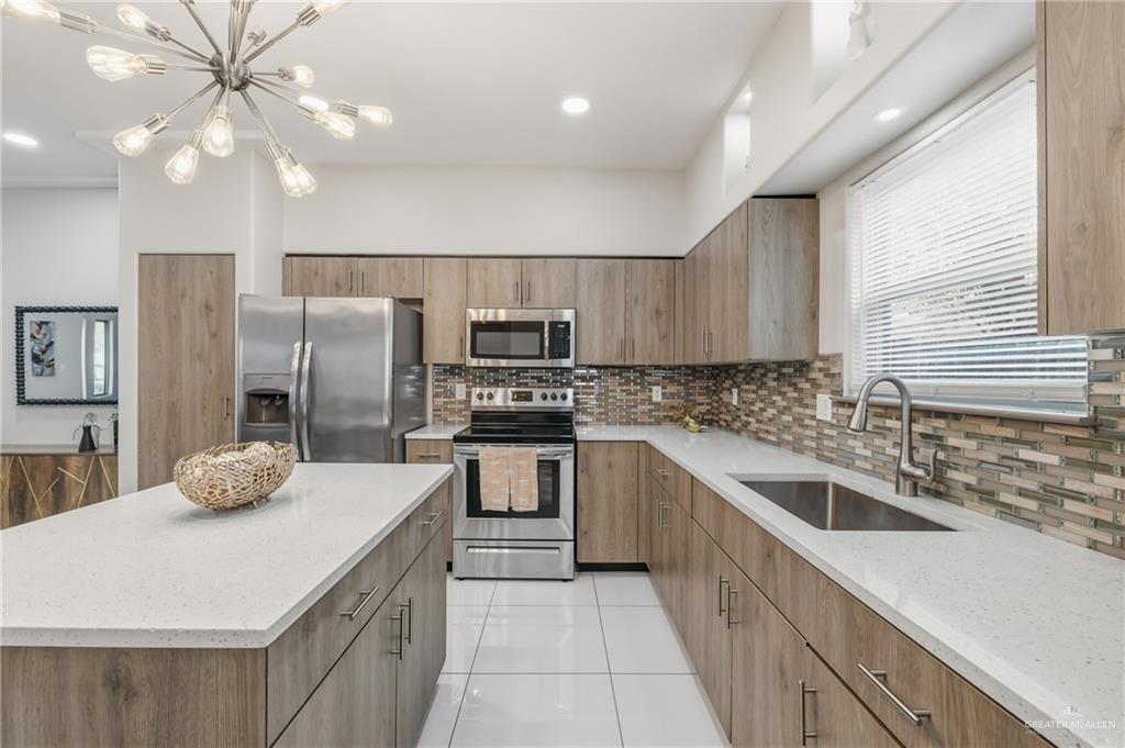 3302 South Sugar Road, Unit H Edinburg, TX 78539 - Photo 4 of 24 a kitchen with stainless steel appliances kitchen island granite countertop a sink a stove a refrigerator cabinets and chairs