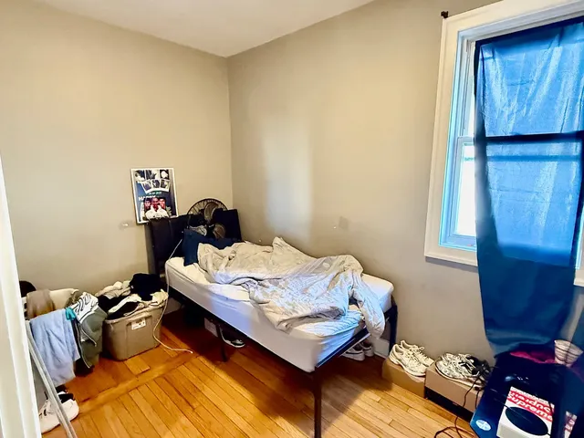 a bed sitting in a bedroom next to a window