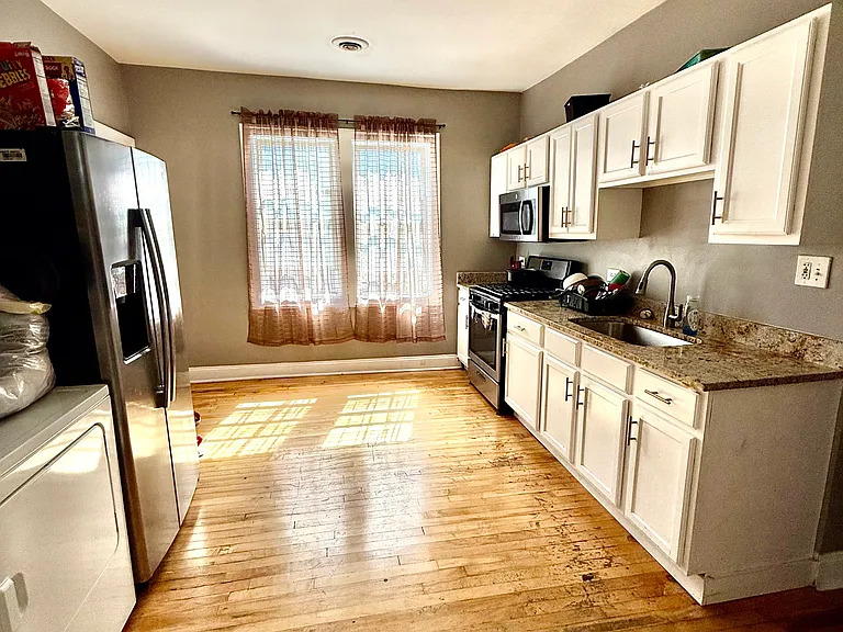 831 North Ashland Avenue, Unit 2 Chicago, IL 60642 - Photo 5 of 12 a kitchen with stainless steel appliances a stove top oven a sink a refrigerator white cabinets and wooden floor