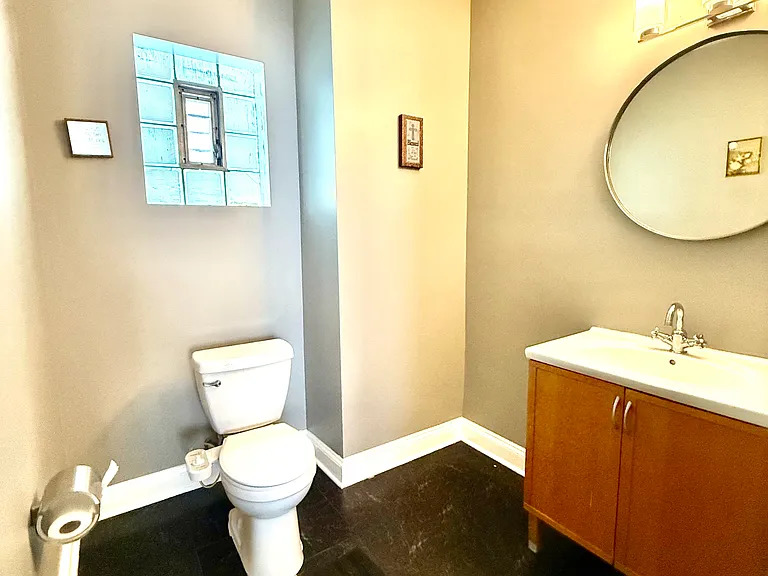 831 North Ashland Avenue, Unit 2 Chicago, IL 60642 - Photo 7 of 12 a bathroom with a toilet sink and mirror