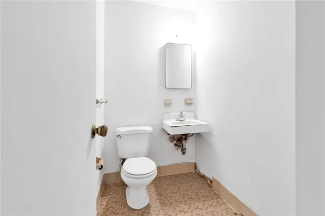 a bathroom with a toilet sink and mirror