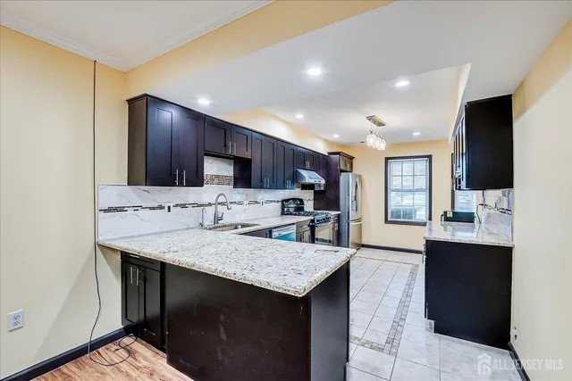 a kitchen with stainless steel appliances granite countertop wooden cabinets a sink and dishwasher