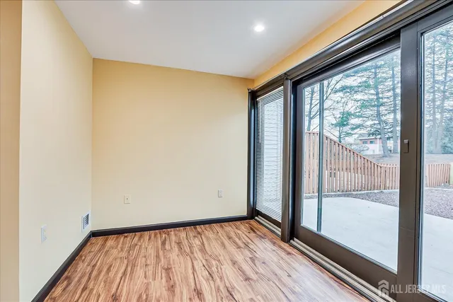 a view of an empty room with wooden floor