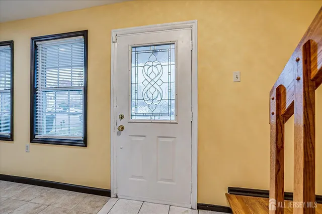 an empty room with wooden floor fireplace and windows