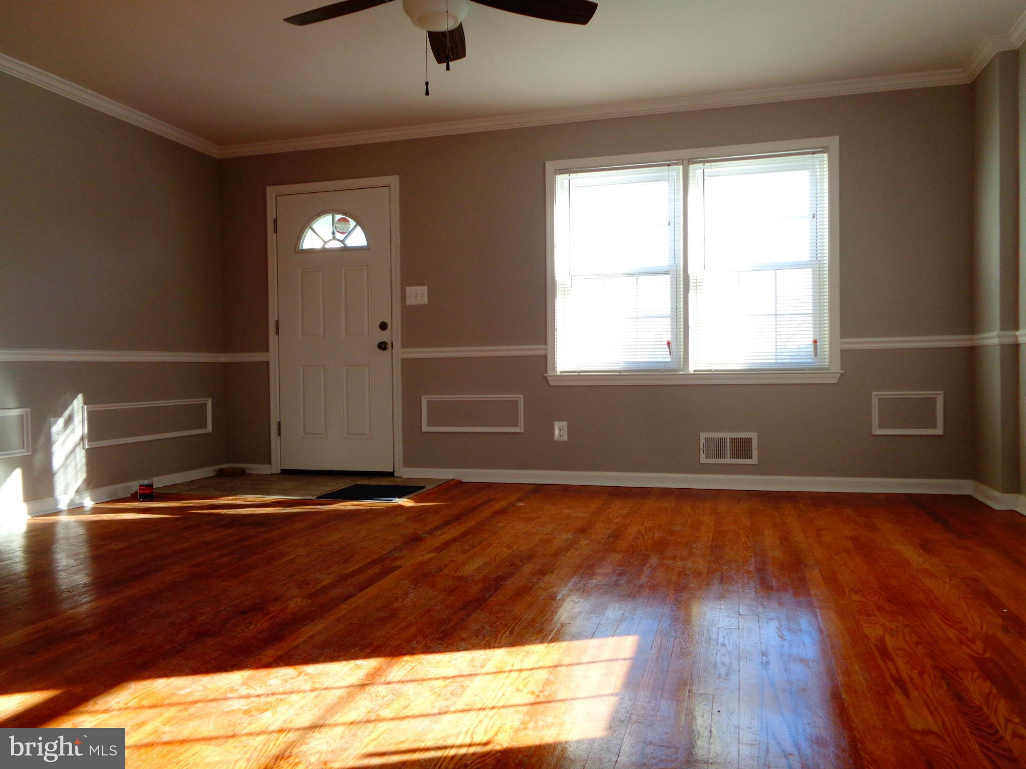 2109 Hawthorne Road Baltimore, MD 21220 - Photo 2 of 28 a view of an empty room with wooden floor and a window