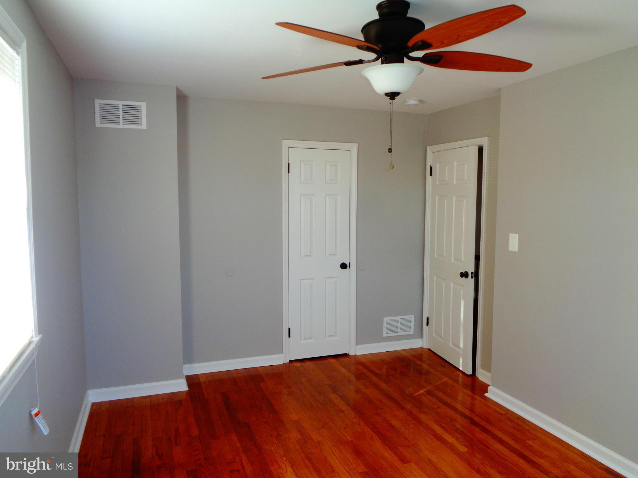 2109 Hawthorne Road Baltimore, MD 21220 - Photo 15 of 28 a view of empty room with wooden floor and fan