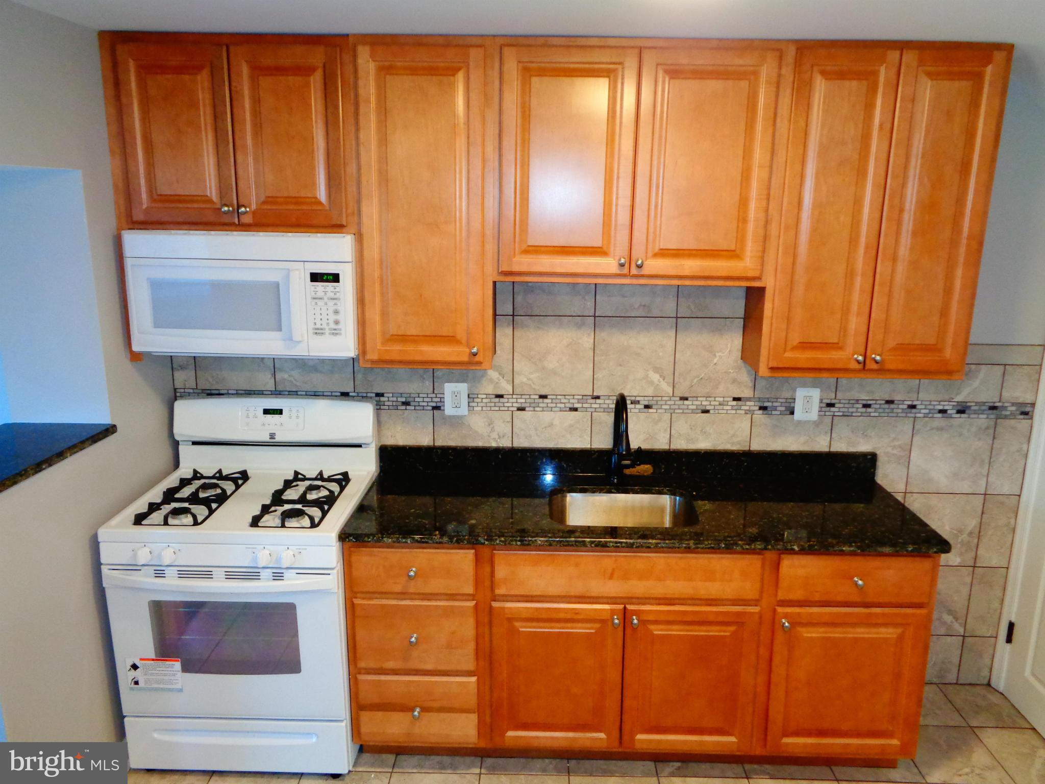 2109 Hawthorne Road Baltimore, MD 21220 - Photo 6 of 28 a kitchen with granite countertop cabinets and black appliances