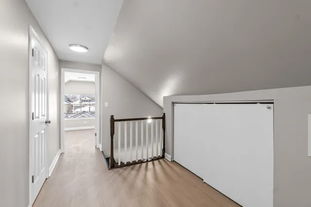 a view of a hallway with wooden floor and door
