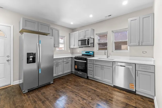 a kitchen with a refrigerator stove top oven and sink