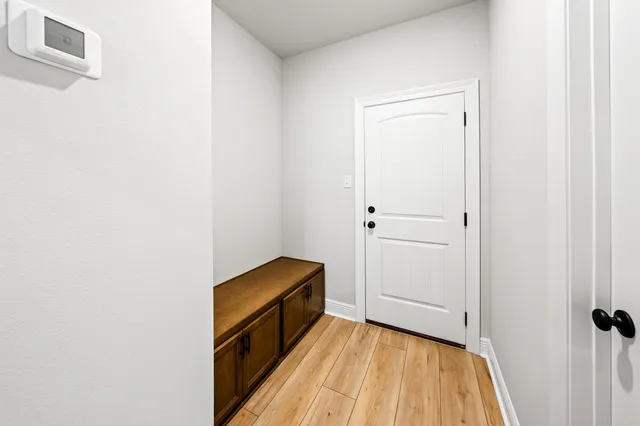 a view of a hallway with wooden floor and staircase