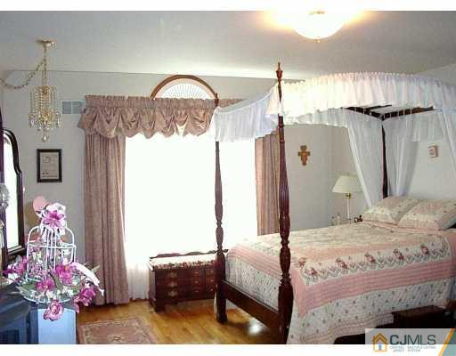 2 Maher Road Somerset County, NJ 08873 - Photo 6 of 8 a bedroom with a bed and a chandelier