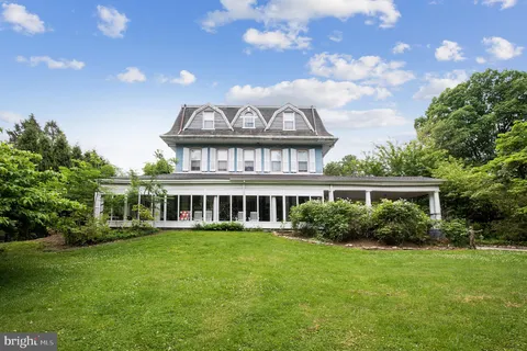 a front view of a house with a garden and lake view