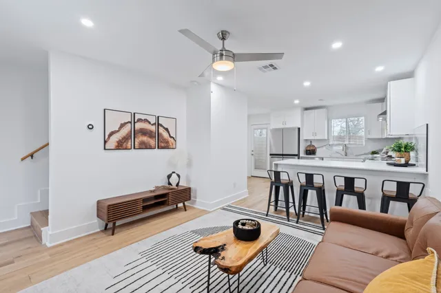 a living room with furniture and a view of kitchen