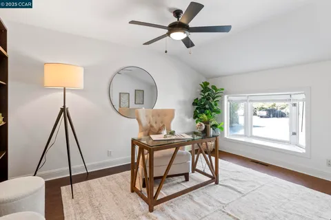 a view of a dining room with furniture a potted plant and wooden floor