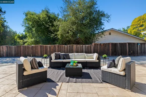 a view of a table and chairs in patio next to a yard
