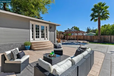 a patio with glass top table and chairs