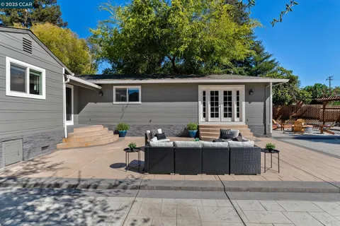a view of a house with backyard and sitting area