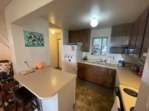 a kitchen with a table chairs refrigerator and microwave