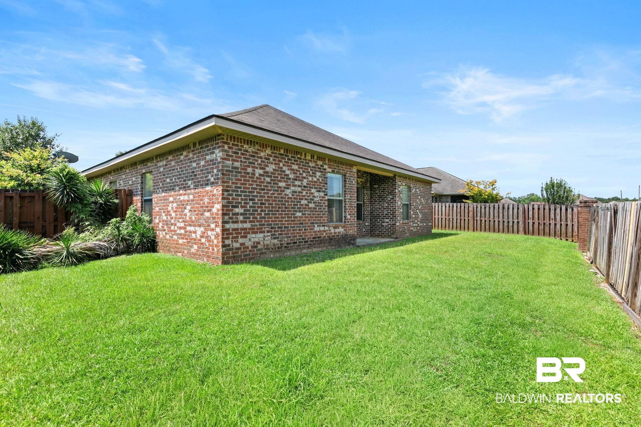 2216 Livingstone Court Mobile, AL 36695 - Photo 43 of 62 Expansive backyard featuring a manicured lawn, full brick exterior, a covered patio area, and a wood privacy fence