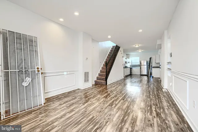 a view of a hallway with wooden floor and staircase