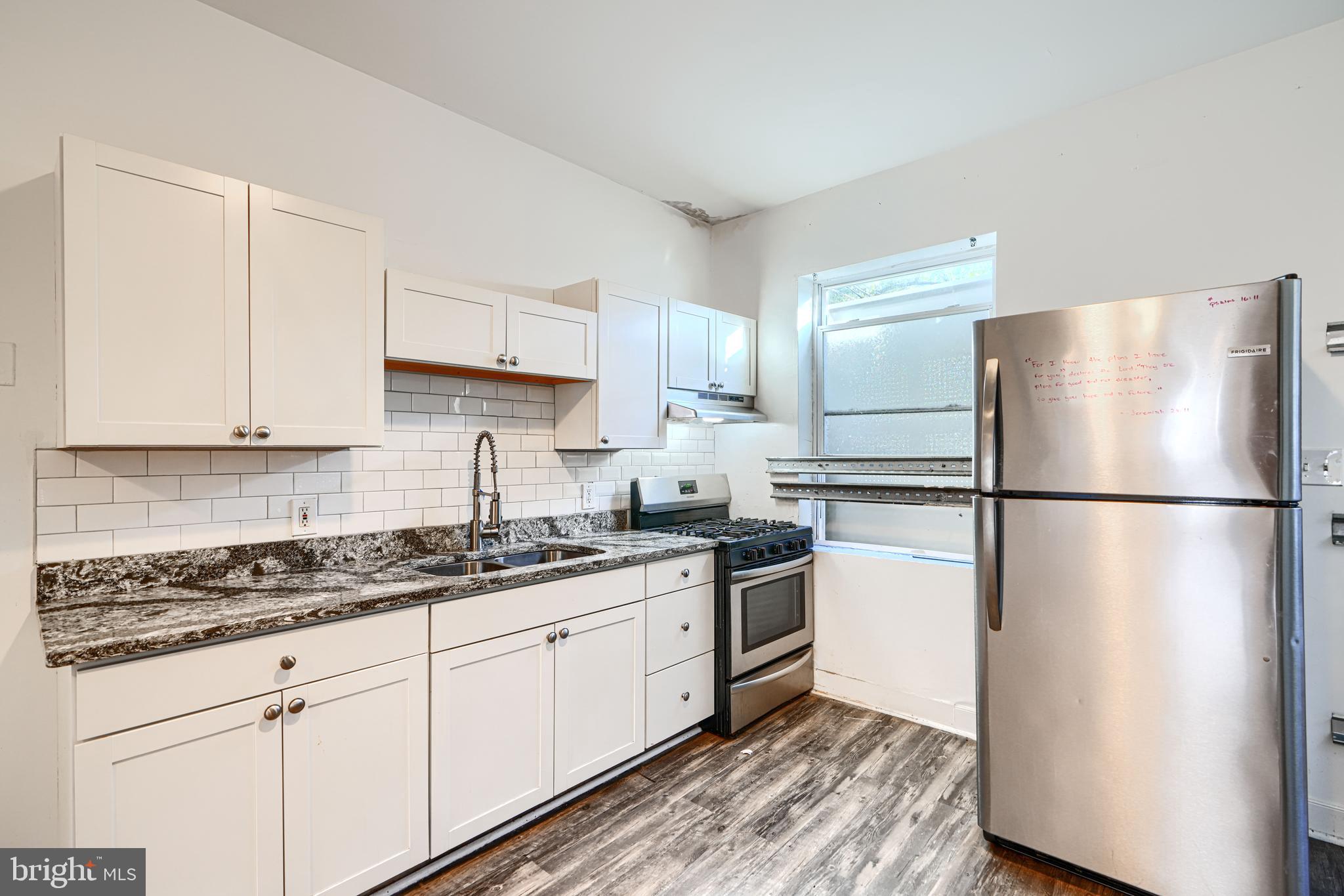 1601 East 28th Street Baltimore, MD 21218 - Photo 16 of 34 a kitchen with stainless steel appliances granite countertop a refrigerator a stove a sink and white cabinets