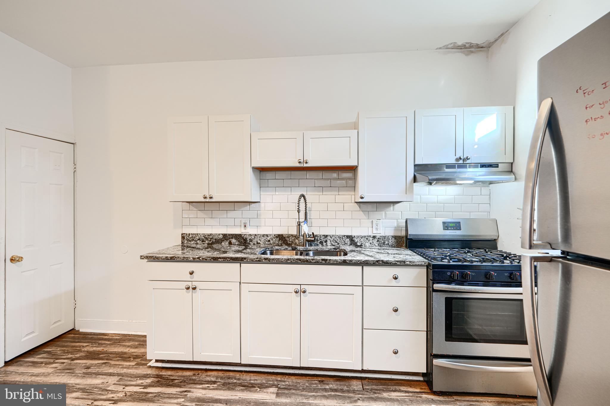 1601 East 28th Street Baltimore, MD 21218 - Photo 17 of 34 a kitchen with stainless steel appliances granite countertop a sink stove and refrigerator