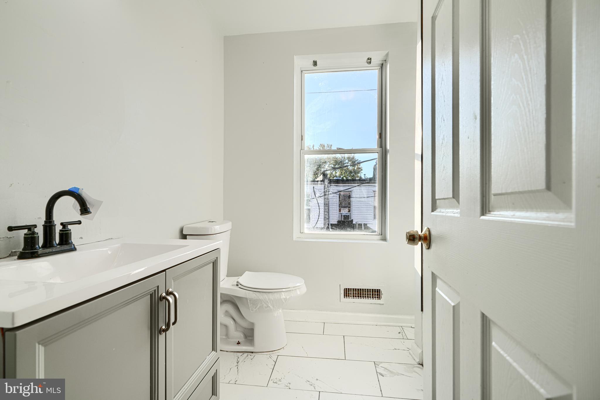 1601 East 28th Street Baltimore, MD 21218 - Photo 21 of 34 a bathroom with a sink and a toilet