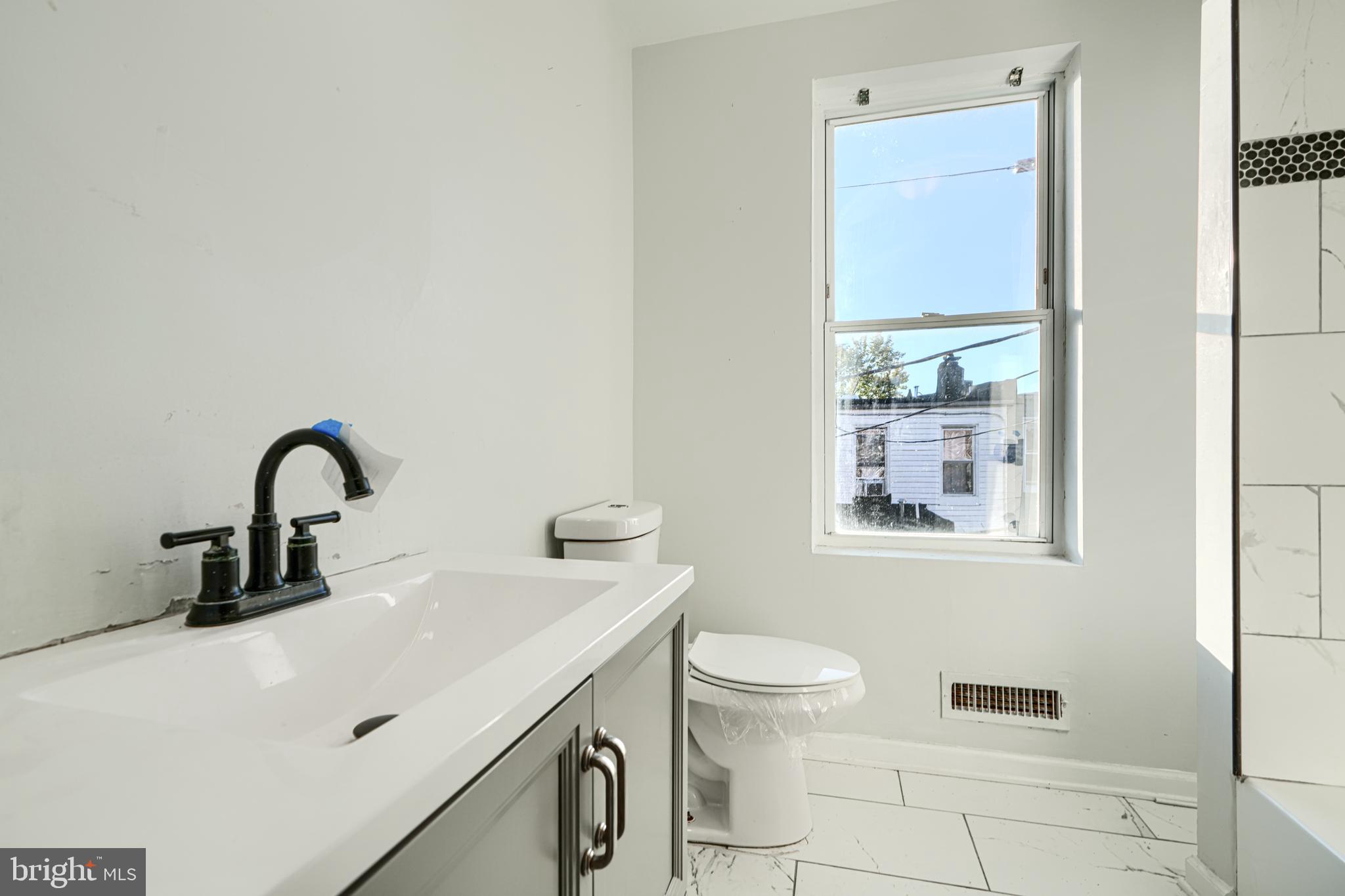 1601 East 28th Street Baltimore, MD 21218 - Photo 22 of 34 a bathroom with a sink and a toilet