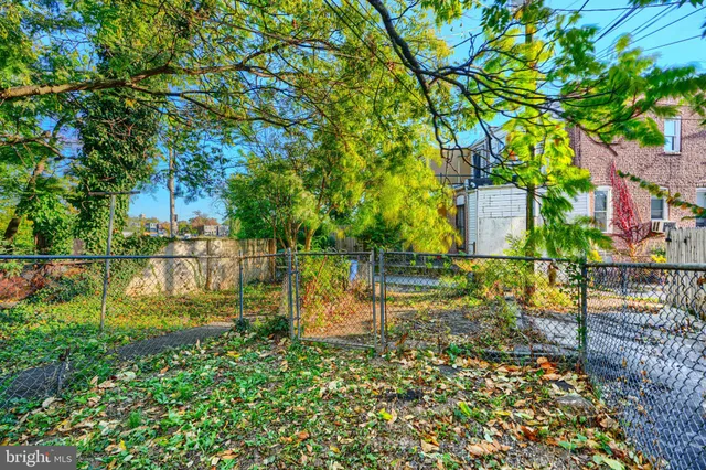 a backyard of a house with lots of green space and fountain in the back