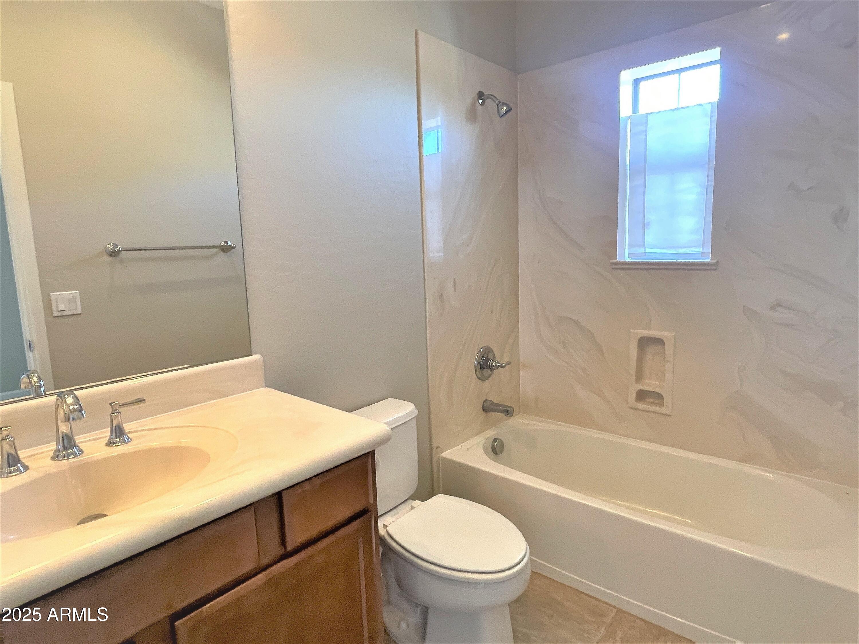 3935 East Rough Rider Road, Unit 1167 Phoenix, AZ 85050 - Photo 20 of 29 a bathroom with a sink toilet vanity and shower