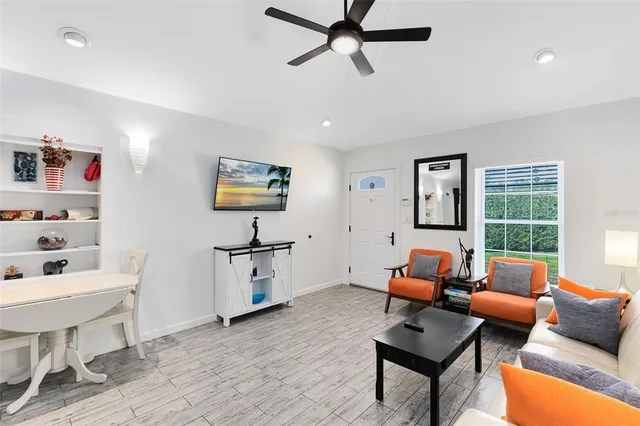 a living room with furniture a window and a flat screen tv