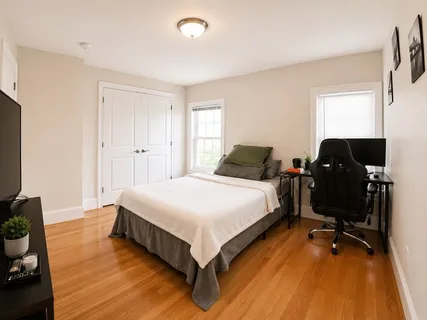 a bedroom with a bed and a flat tv screen on the dresser
