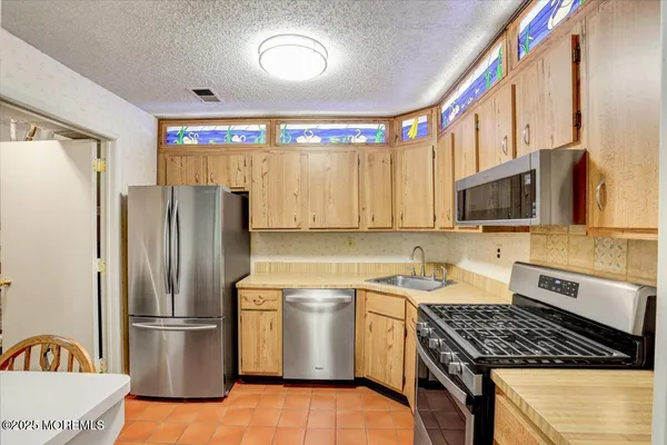 a kitchen with a refrigerator a stove a sink and a microwave