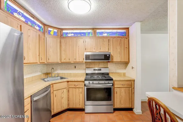 a kitchen with a sink cabinets and stainless steel appliances