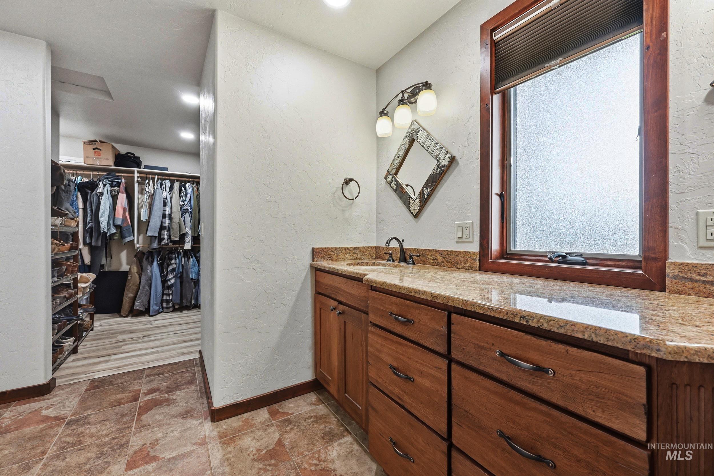 339 Airport Road Weiser, ID 83672 - Photo 26 of 49 Bathroom vanity with a granite countertop, wood cabinetry, and a framed window