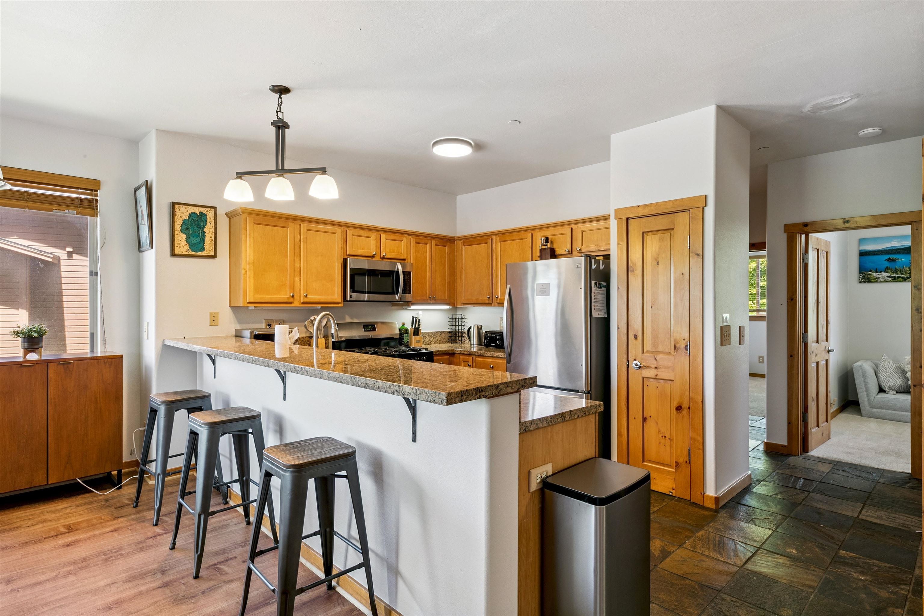 10592 Boulders Road, Unit 8 Truckee, CA 96161 - Photo 6 of 27 a kitchen with stainless steel appliances granite countertop a refrigerator a stove and a sink with wooden floor
