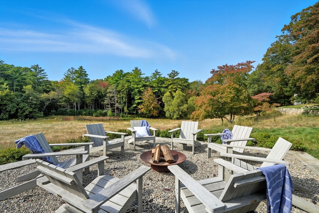 65 Partridge Road Duxbury, MA 02332 - Photo 41 of 42 a view of a patio with couches chairs and a table and chairs under an umbrella