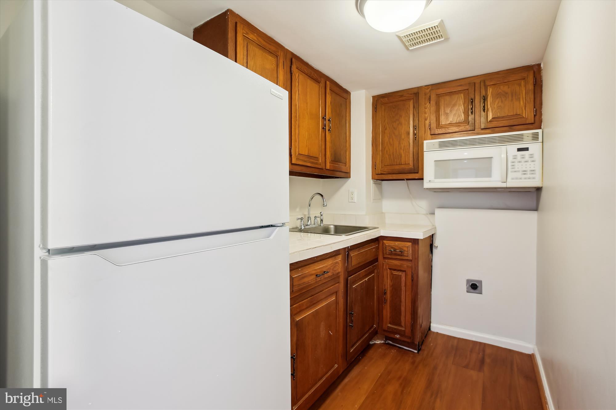 3530 Quesada Street Northwest Washington, DC 20015 - Photo 38 of 54 a kitchen with stainless steel appliances granite countertop a refrigerator a microwave a sink and cabinets